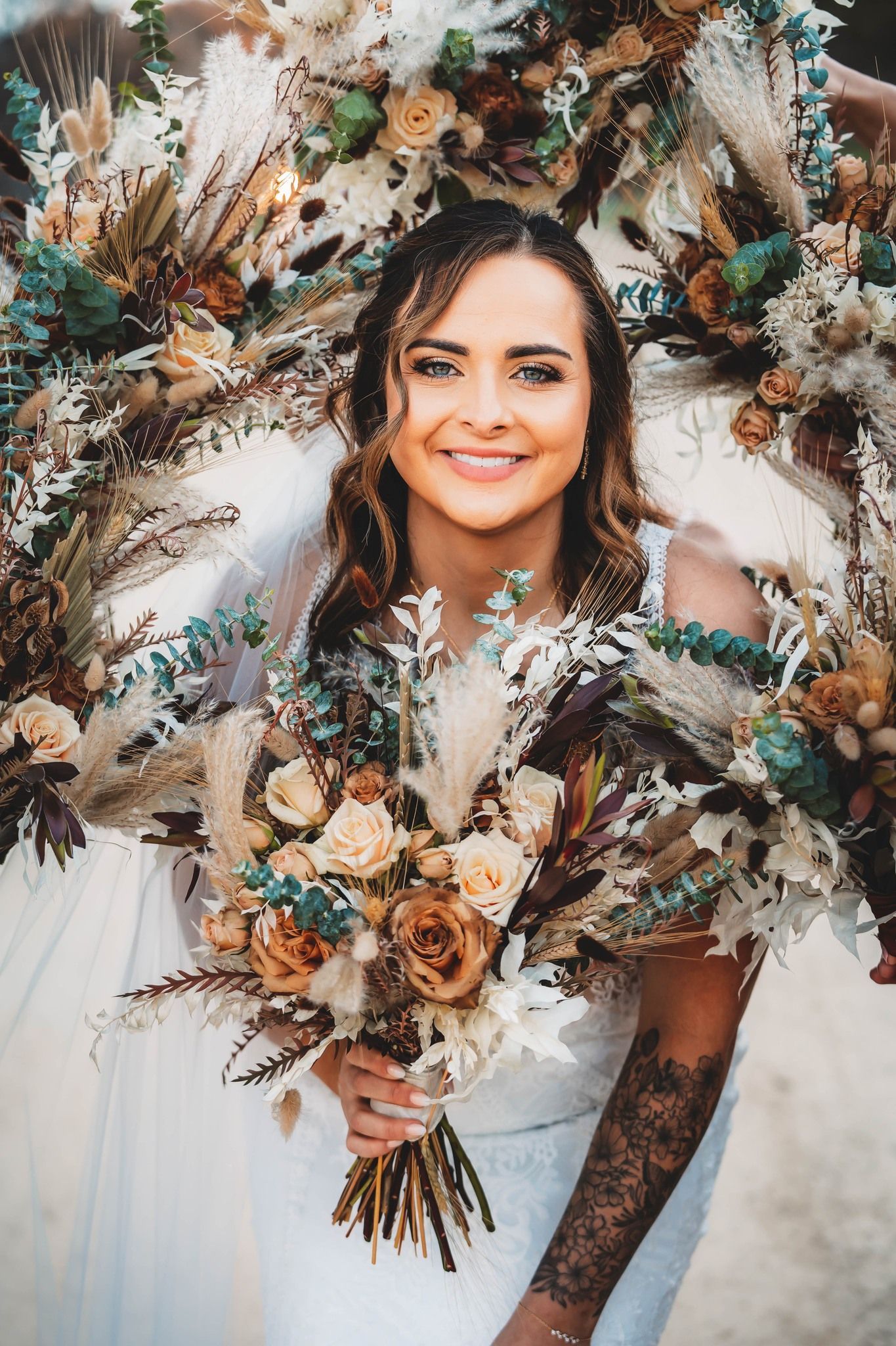 A bride in a white dress is holding a bouquet of dried flowers. A bride in a white dress is holding a bouquet of dried flowers.