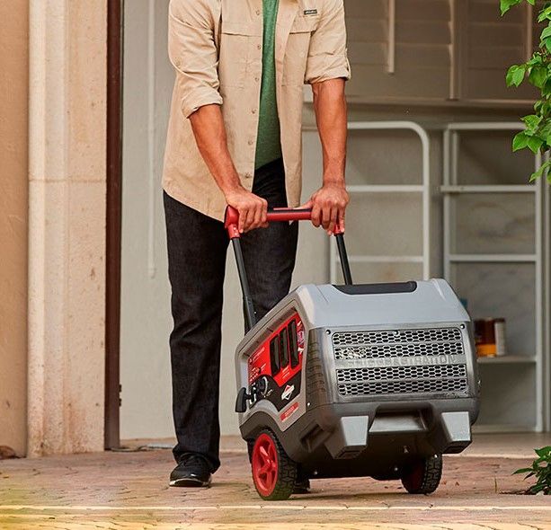 A Man is Pushing a Generator on a Cart — Jacksons Mower Centre in Mackay, QLD