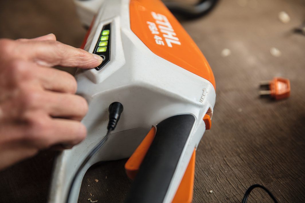 A Person is Pressing a Button on a Stihl Tool — Jacksons Mower Centre in Mackay, QLD
