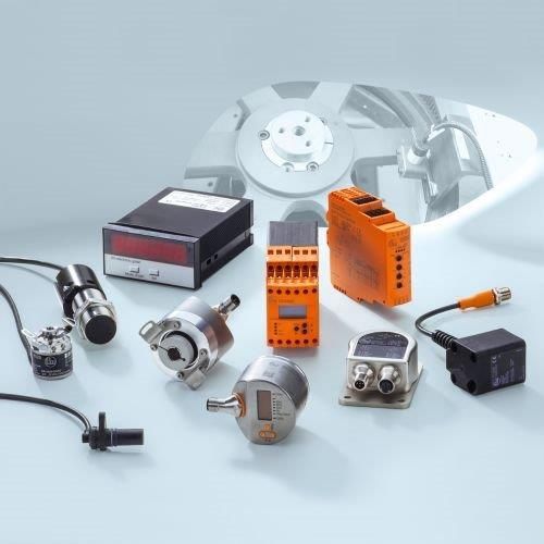 Vari sensori industriali e componenti elettronici su sfondo grigio.