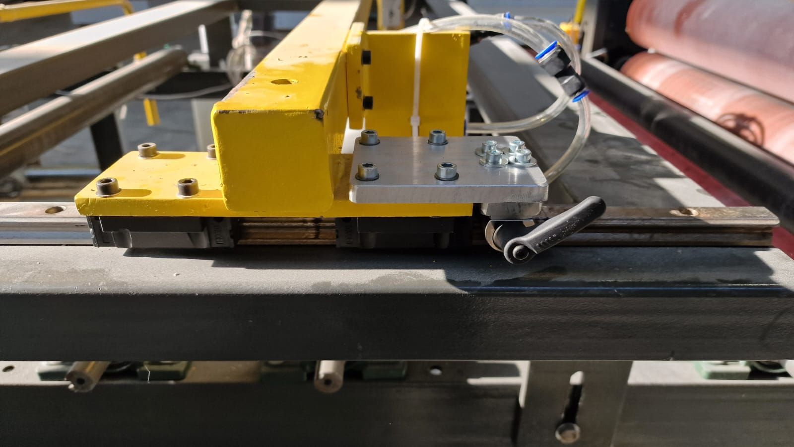 Un braccio robotico giallo con hardware argentato è fissato a una struttura metallica.