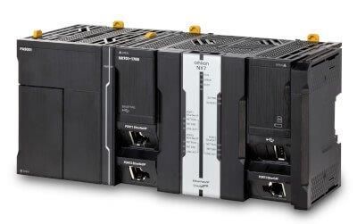 Apparecchiatura di automazione industriale nera, con vari moduli e connettori, probabilmente destinata a un'installazione di fabbrica.