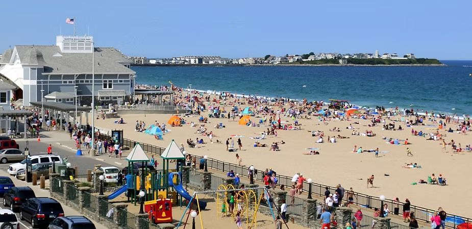 A very crowded beach with a playground in the foreground