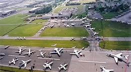 A bunch of airplanes are parked on a runway