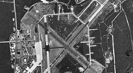 A black and white aerial view of an airport runway.