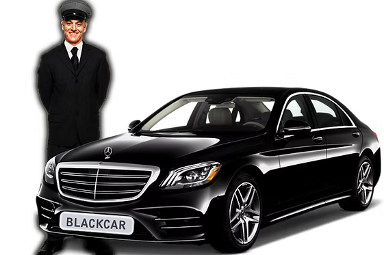 A man in a suit and tie is standing next to a black car.