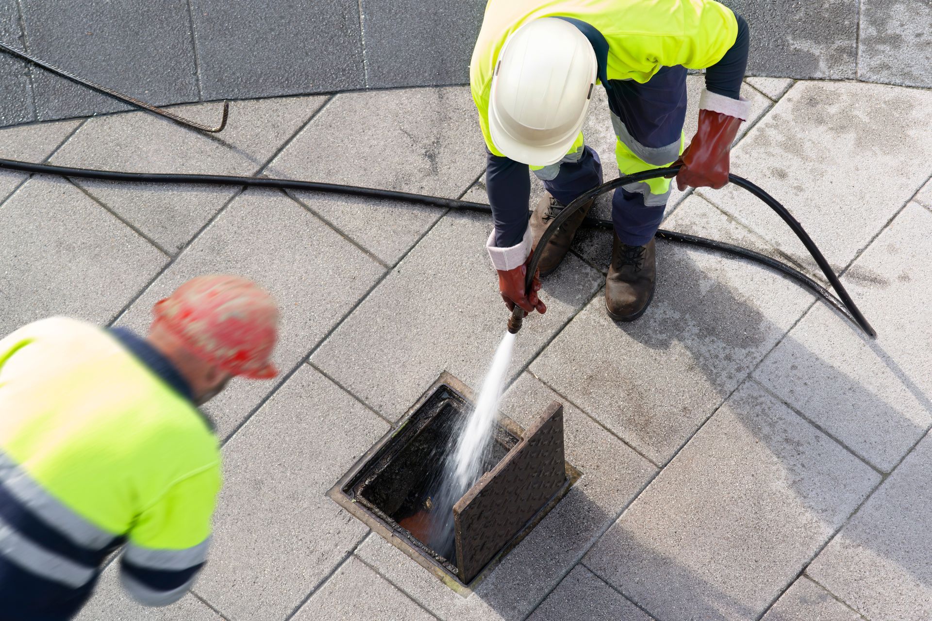 Sewer workers cleaning with water pressure on maintenance by the system sewage. Sewer workers cleaning with water pressure on maintenance by the system sewage.