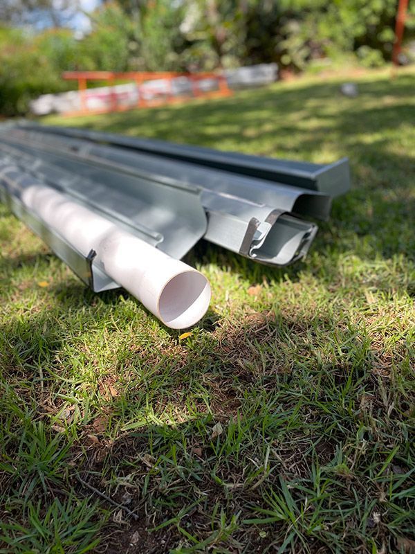 A Couple Of Pipes Sitting On Top Of A Lush Green Field — BJB Plumbing & Gasfitting in Dubbo, NSW