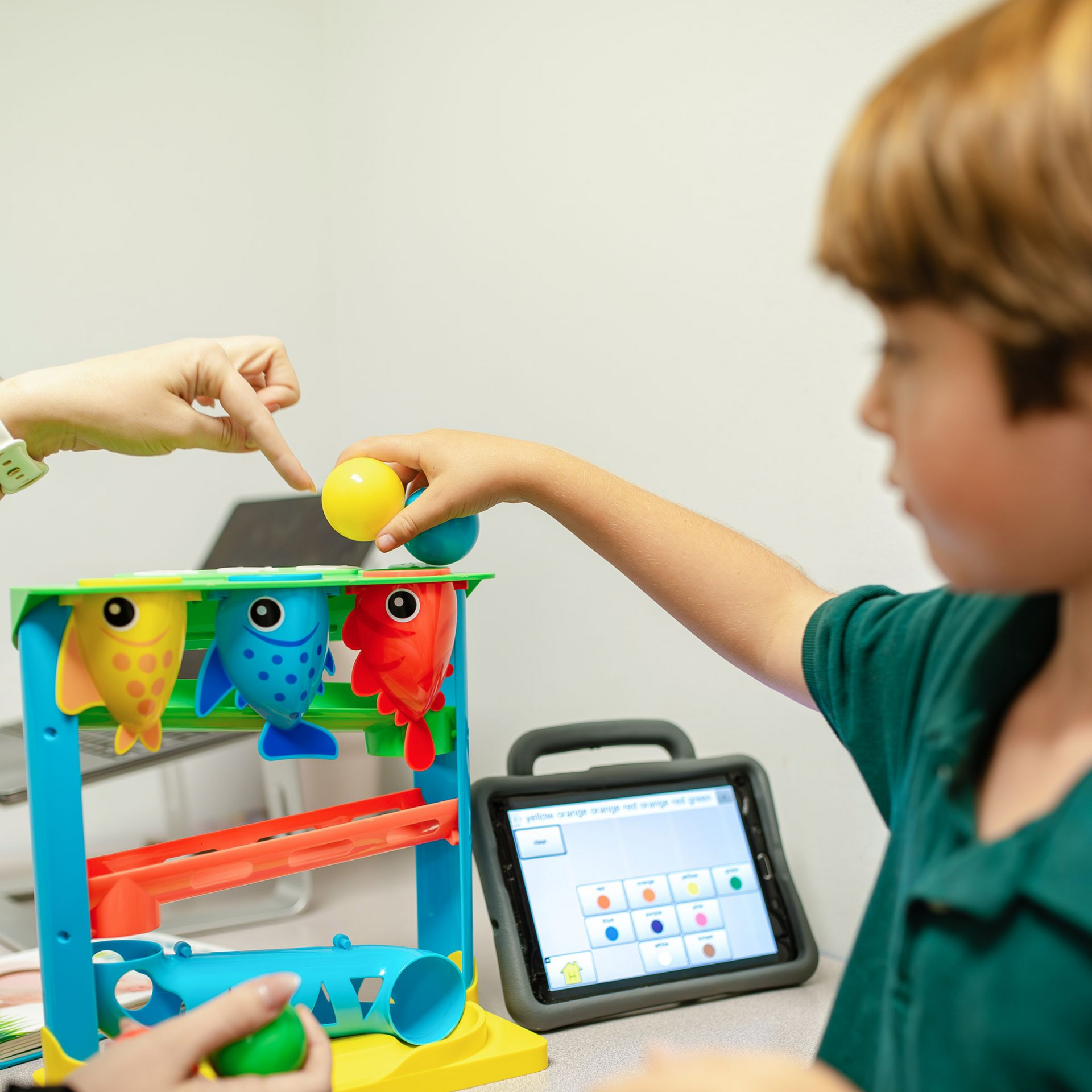 Young child stacking colorful blocks on a table in a classroom setting