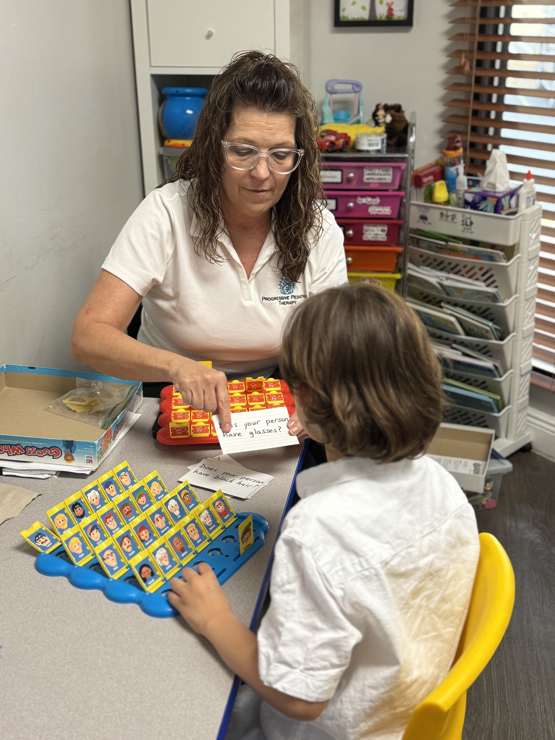 Two people at a table playing a colorful matching game in a classroom or office setting