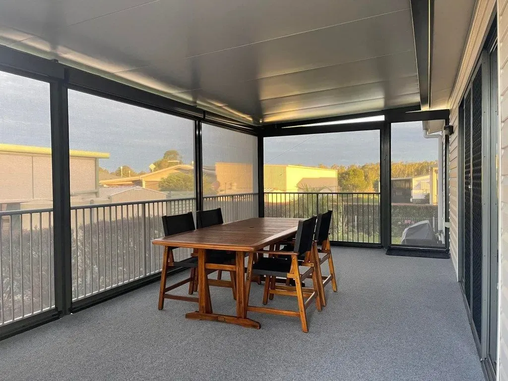 A Large Screened in Porch With a Table and Chairs — Dennys Upholstery & Outdoor Blinds In South Lismore, NSW