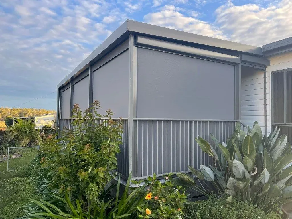 A House With a Screened in Porch and a Fence Surrounded by Plants — Dennys Upholstery & Outdoor Blinds In South Lismore, NSW