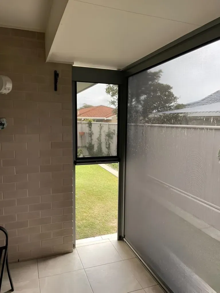 A Room With a Large Window and a Brick Wall — Dennys Upholstery & Outdoor Blinds In Byron, NSW