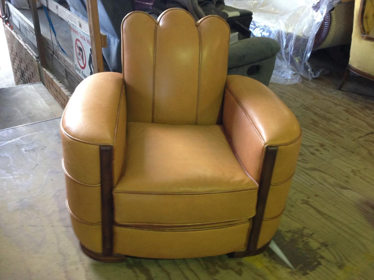 A Brown Leather Chair is Sitting on a Wooden Floor — Dennys Upholstery & Outdoor Blinds In Casino, NSW