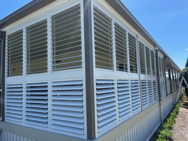 A House With a Lot of Windows and Shutters on It — Dennys Upholstery & Outdoor Blinds In Byron, NSW