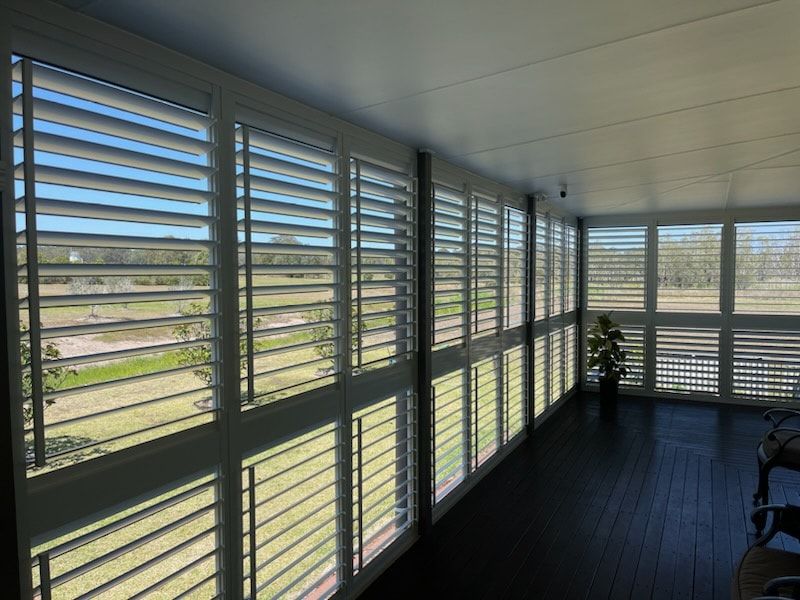 A Room With a Lot of Windows and Shutters on Them — Dennys Upholstery & Outdoor Blinds In Byron, NSW