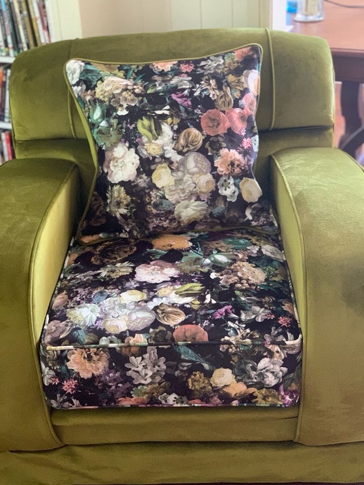 A Green Chair With a Floral Pillow on It — Dennys Upholstery & Outdoor Blinds In Byron, NSW
