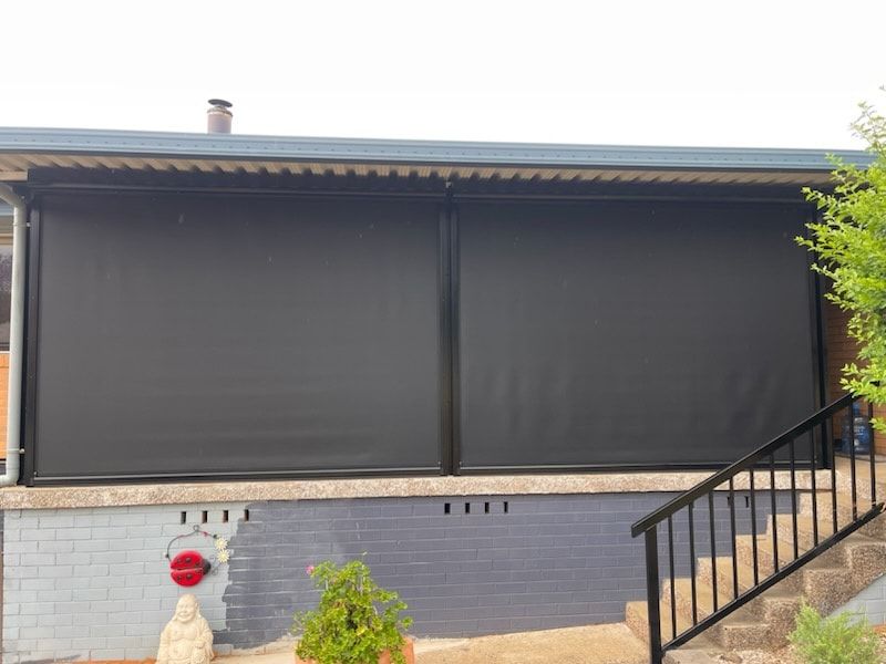 A House With a Black Awning on the Side of It and Stairs Leading Up to It — Dennys Upholstery & Outdoor Blinds In Byron, NSW