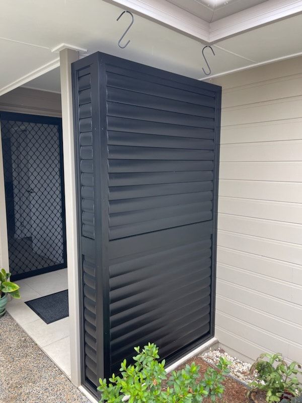 A Black Shutter is on the Side of a House — Dennys Upholstery & Outdoor Blinds In Evans Head, NSW