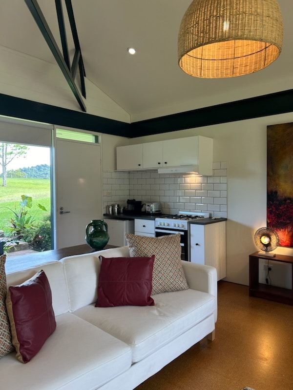 A Living Room With a Couch and a Kitchen in the Background — Dennys Upholstery & Outdoor Blinds In Evans Head, NSW