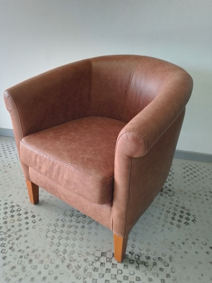 A Brown Leather Chair is Sitting on a Checkered Floor — Dennys Upholstery & Outdoor Blinds In Casino, NSW