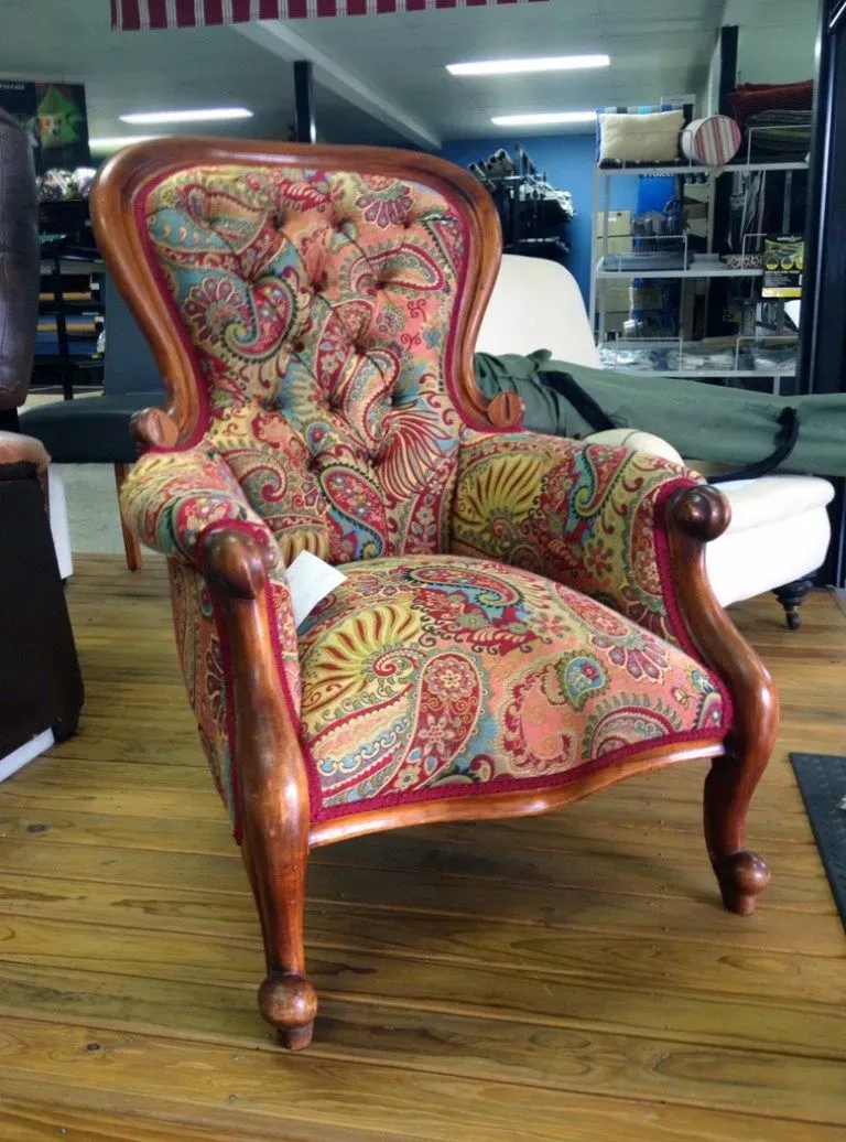 A Colourful Chair is Sitting on a Wooden Floor in a Room — Dennys Upholstery & Outdoor Blinds In South Lismore, NSW
