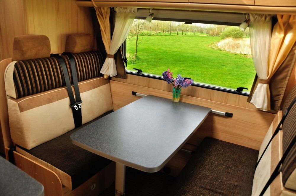 A Table in a Camper With a Vase of Flowers on It — Dennys Upholstery & Outdoor Blinds In Lismore, NSW