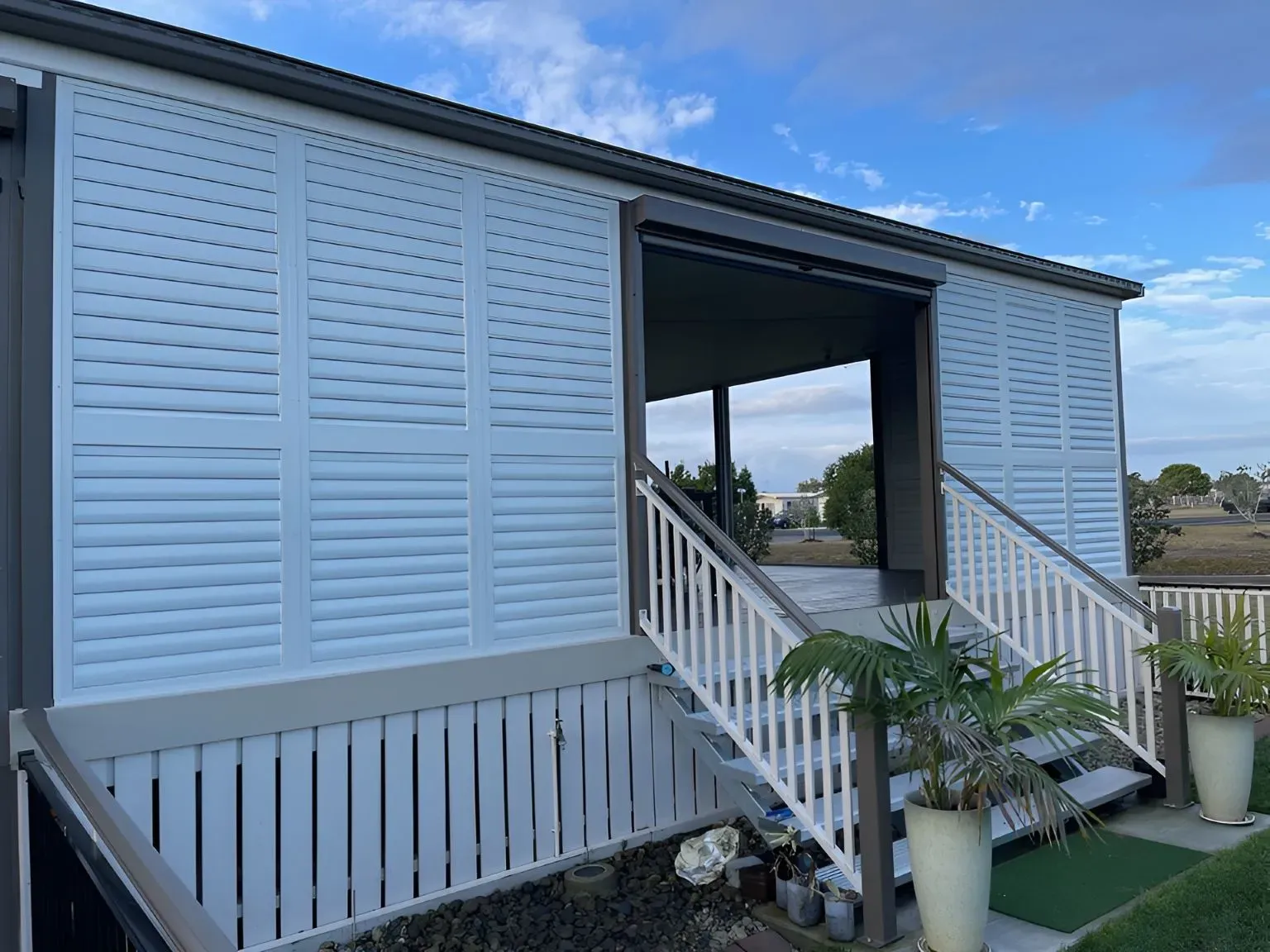 A White House With a Porch and Stairs — Dennys Upholstery & Outdoor Blinds In South Lismore, NSW