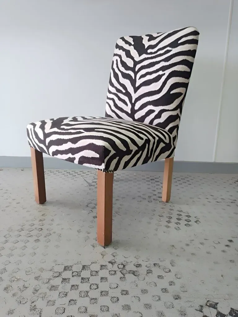 A Black and White Zebra Print Chair With Wooden Legs — Dennys Upholstery & Outdoor Blinds In Lismore, NSW