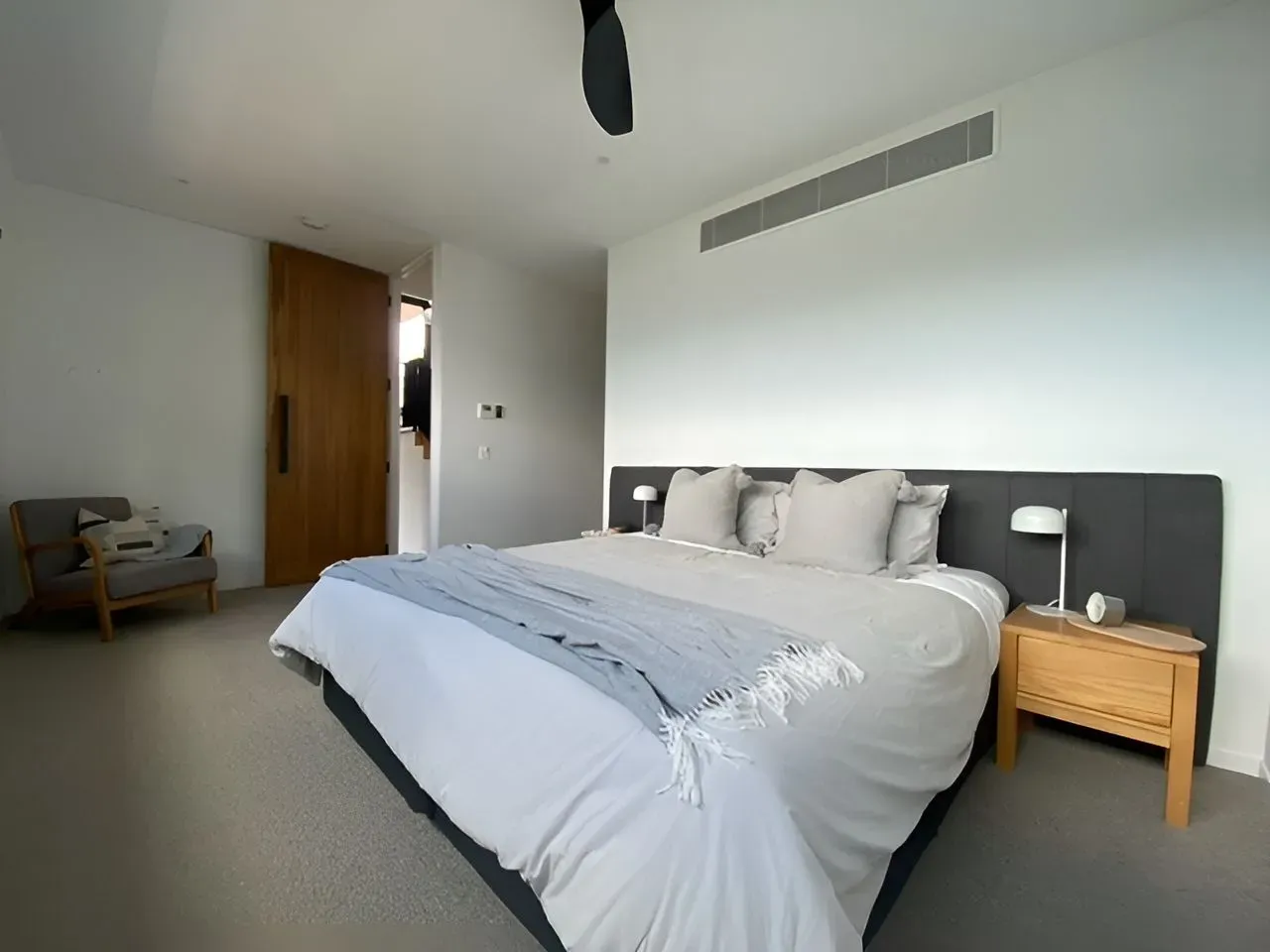 A Bedroom With a Large Bed and a Ceiling Fan — Dennys Upholstery & Outdoor Blinds In Ballina, NSW