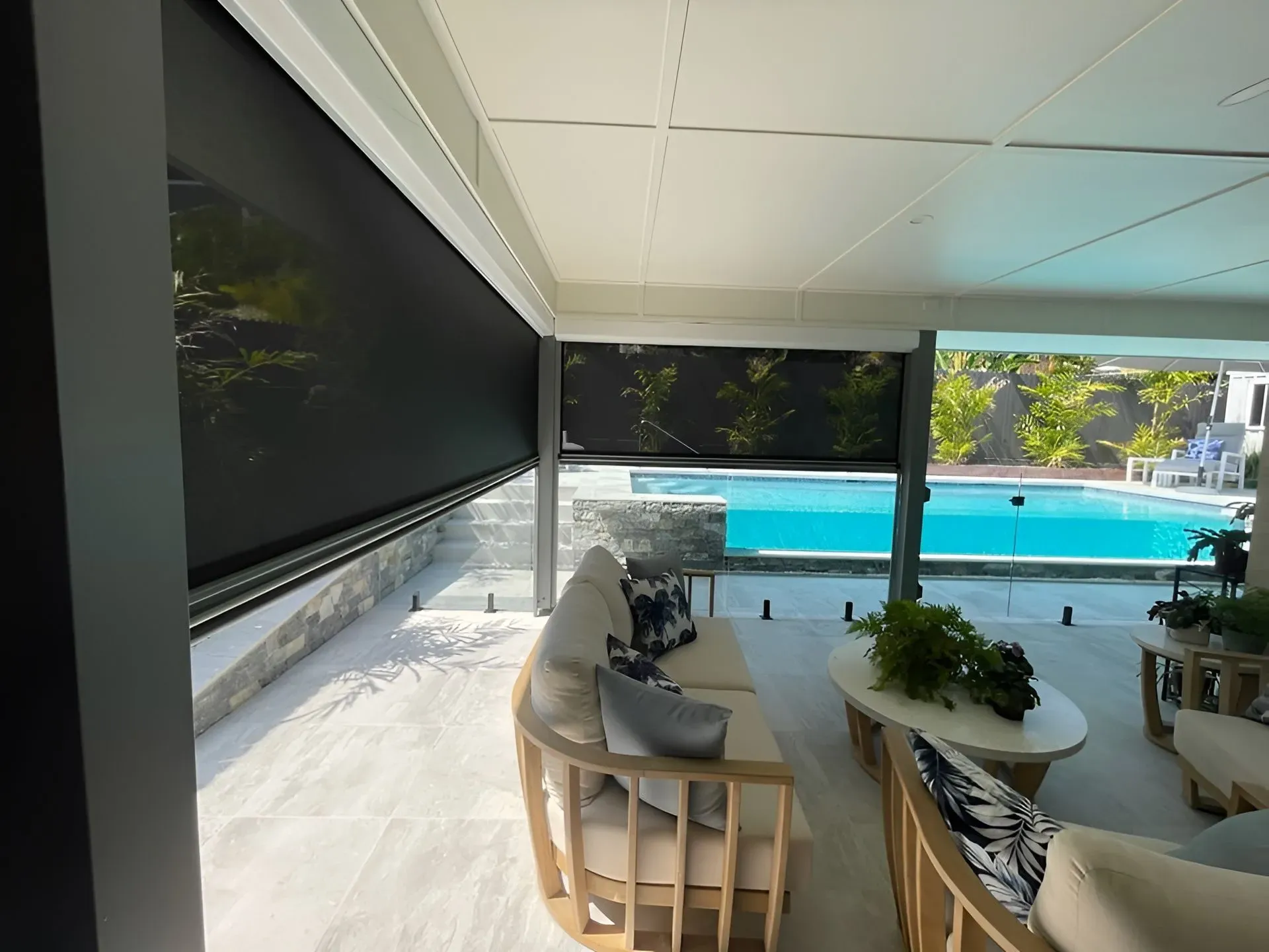 A Living Room With a Couch and Chairs Next to a Pool — Dennys Upholstery & Outdoor Blinds In South Lismore, NSW