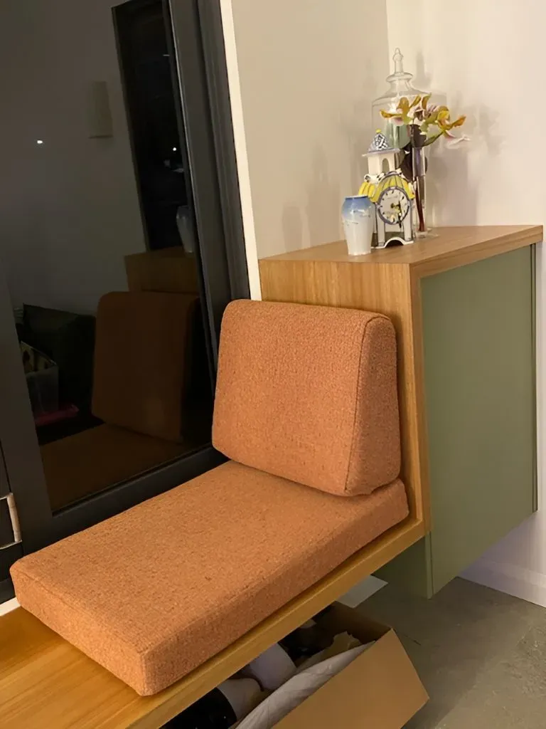 A Chair is Sitting on a Wooden Bench Next to a Window — Dennys Upholstery & Outdoor Blinds In Casino, NSW