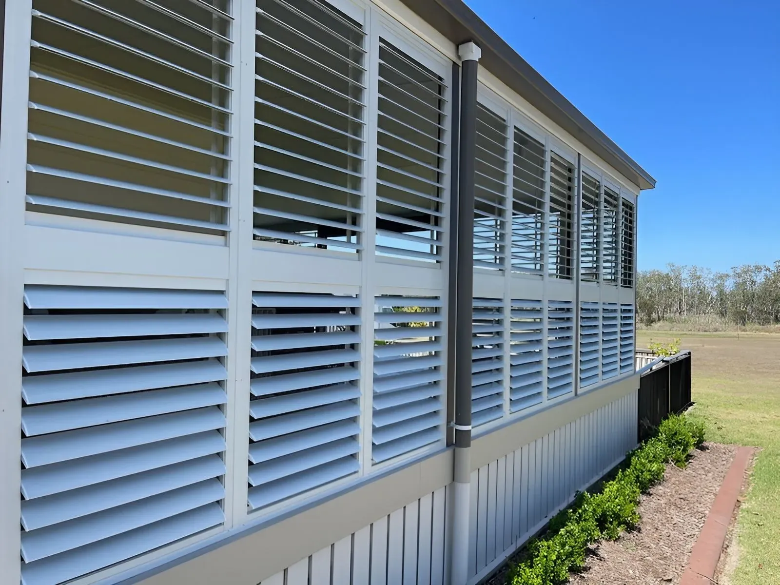 A Building With a Lot of Shutters on It — Dennys Upholstery & Outdoor Blinds In Ballina, NSW