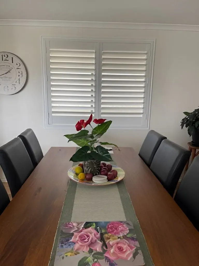 A Dining Room Table With a Plate of Fruit and Flowers on It — Dennys Upholstery & Outdoor Blinds In South Lismore, NSW