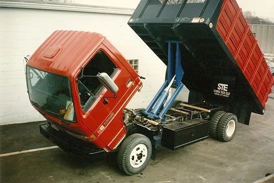 A red dump truck is parked on the side of the road