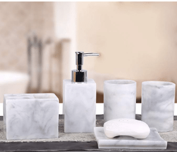 A bathroom set made of marble with a soap dispenser , toothbrush holder , cups , and soap dish.