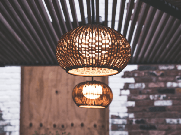 Two wicker lamps are hanging from the ceiling in a room