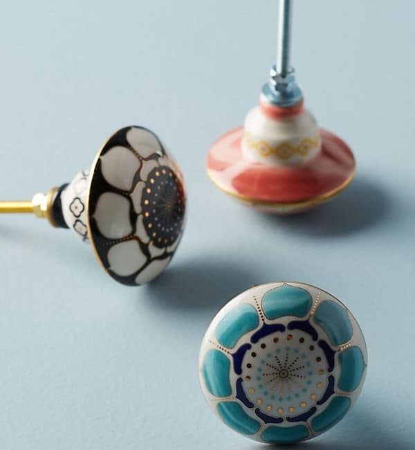 Three different colored knobs are sitting on a blue surface