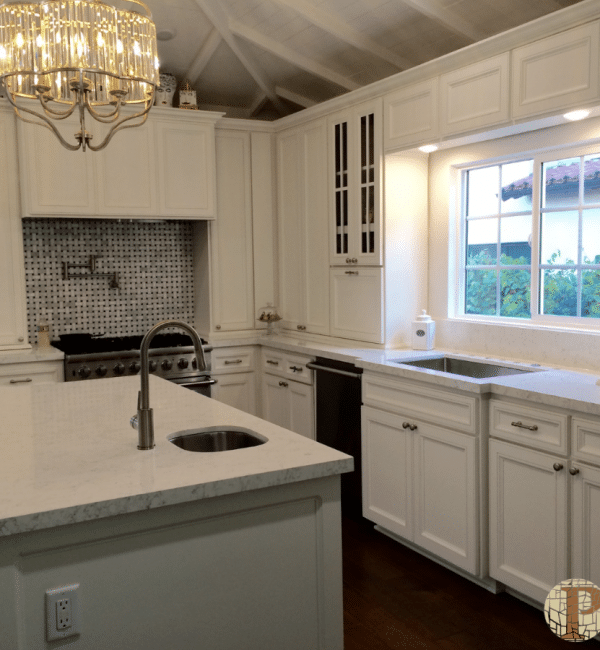 A kitchen with white cabinets and a sink
