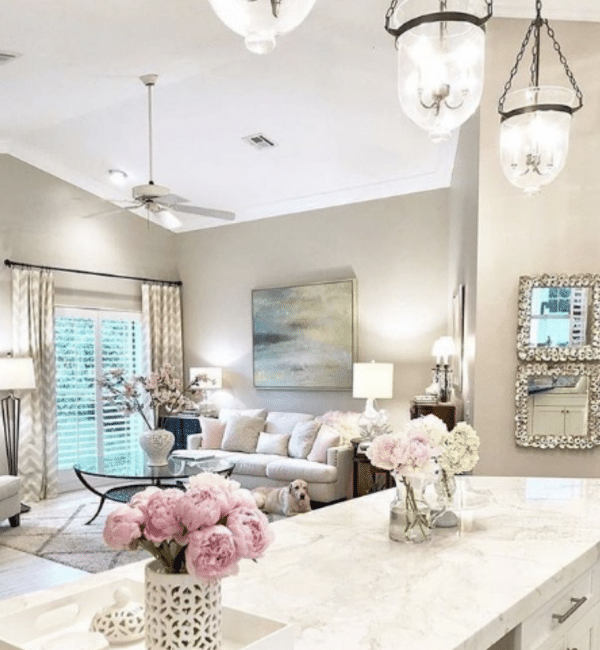 A vase of pink flowers sits on a counter in a living room