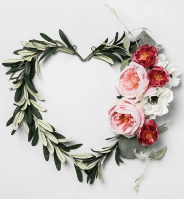 A heart shaped wreath made of flowers and leaves