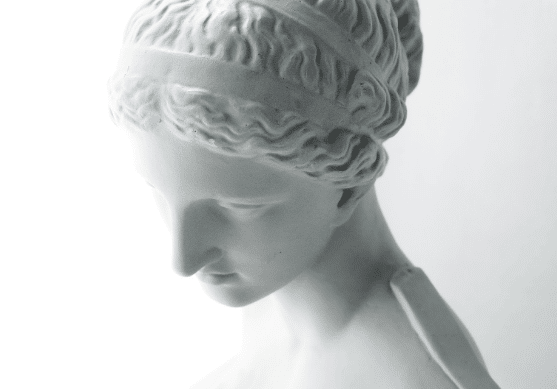A close up of a statue of a woman 's head on a white background.