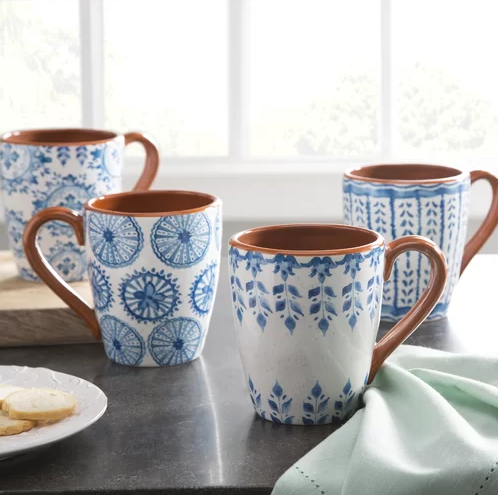Four blue and white coffee mugs are sitting on a counter