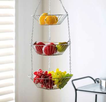 Three baskets of fruit are hanging from a chain