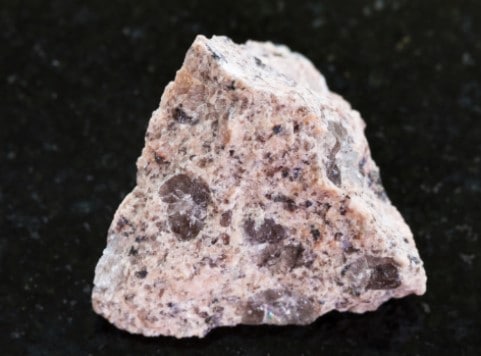 A close up of a rock on a black surface.