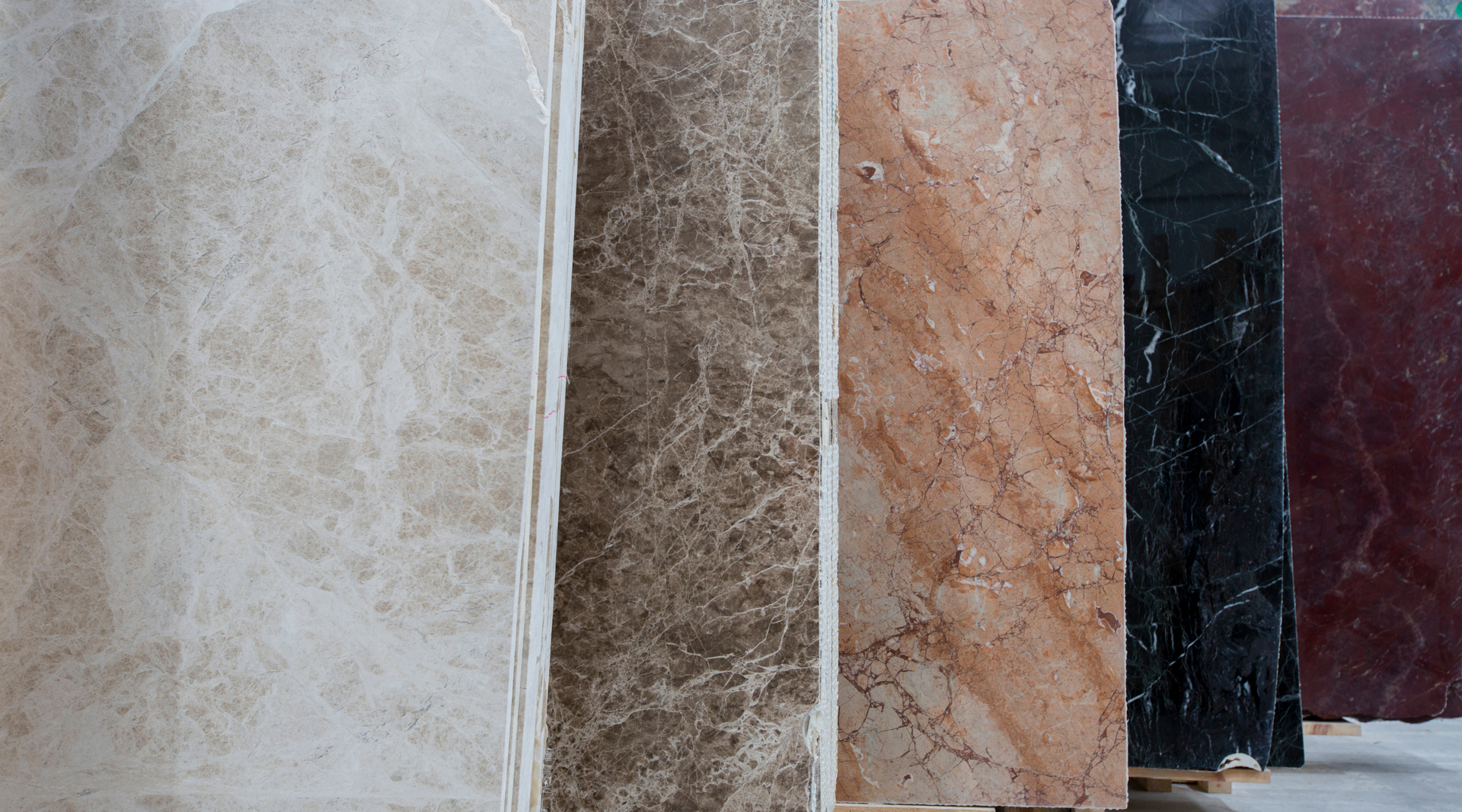 A row of different colored marble slabs are lined up in a row.