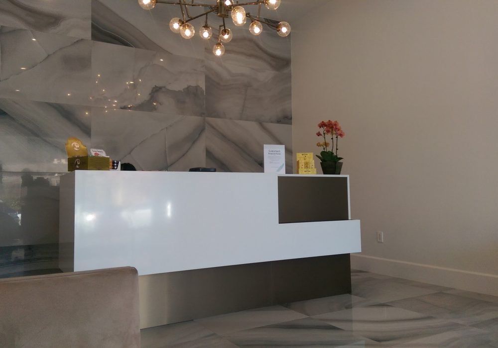A white reception desk in a room with a chandelier