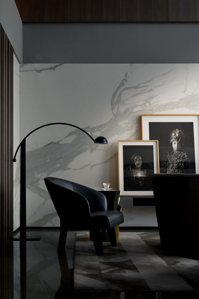 A living room with a black chair and a lamp