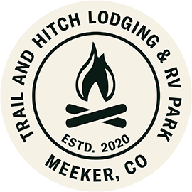 The logo for trail and hitch lodging and rv park in meeker , co.