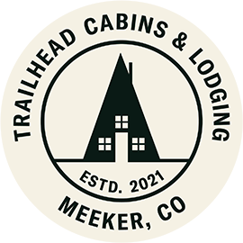 A logo for trailhead cabins and lodging in meeker , co.